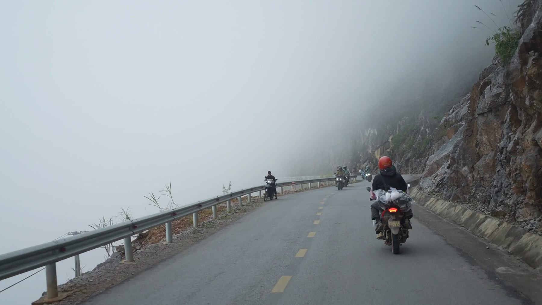 Motorbikes on a fog-covered mountain road in Ha Giang