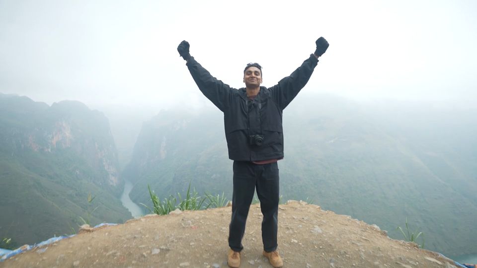 Harsha with his arms up above the Nho Que canyon